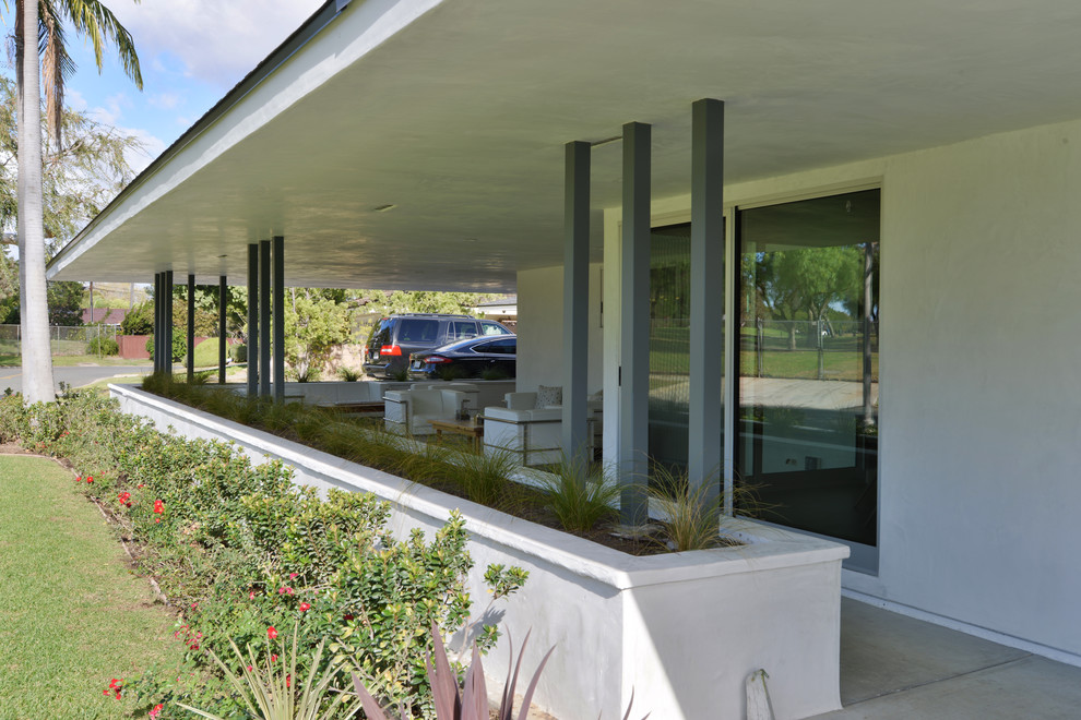 На фото: веранда среднего размера на переднем дворе в стиле модернизм с покрытием из бетонных плит и навесом с