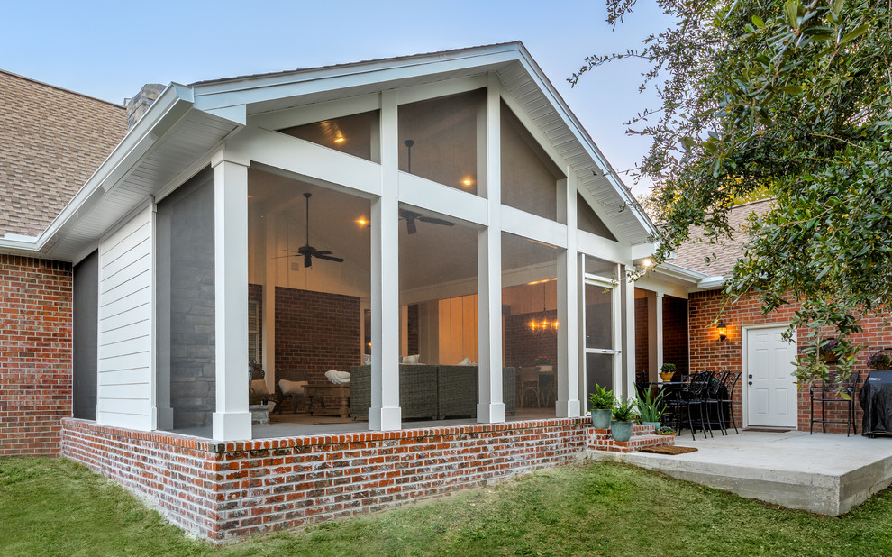 Große, Verglaste, Überdachte Klassische Veranda hinter dem Haus mit Betonplatten in Sonstige