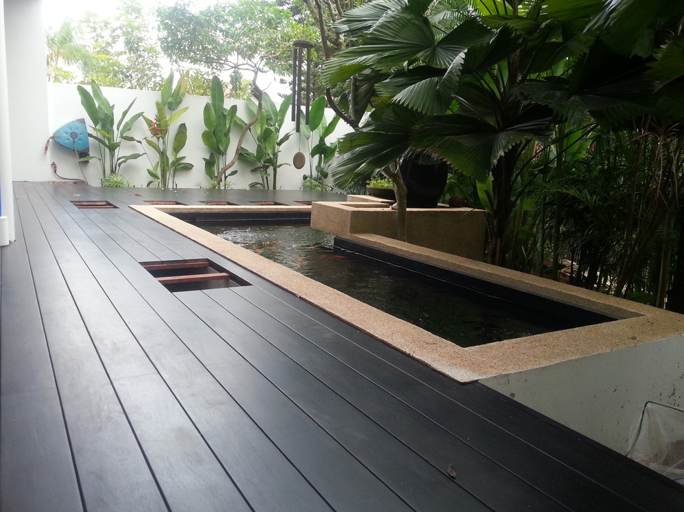 Ejemplo de terraza tropical de tamaño medio en patio delantero con entablado