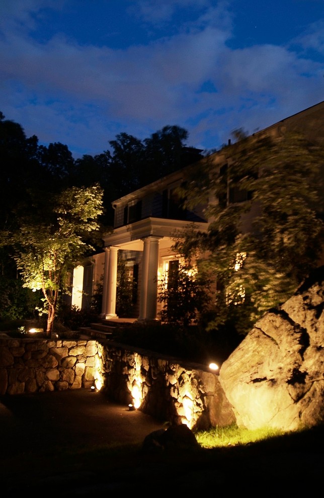 Imagen de terraza clásica grande en patio delantero con adoquines de piedra natural y toldo
