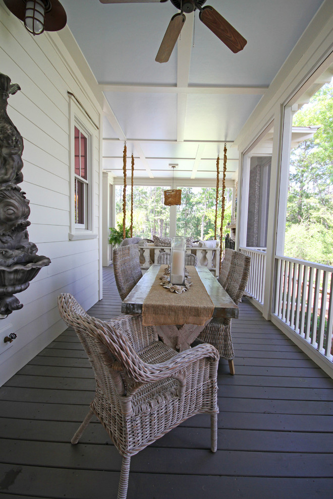 Bild på en mellanstor maritim veranda på baksidan av huset, med en öppen spis, trädäck och takförlängning