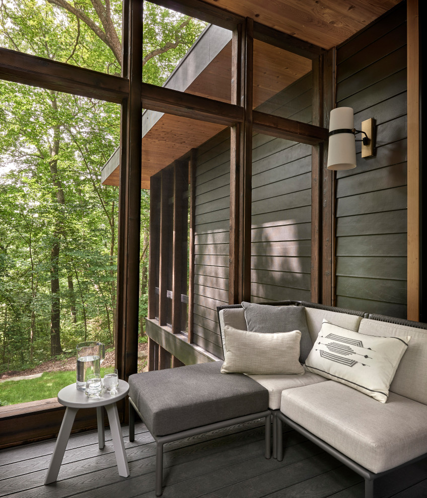 Idée de décoration pour un porche d'entrée de maison latéral chalet de taille moyenne avec une moustiquaire, une terrasse en bois et une extension de toiture.