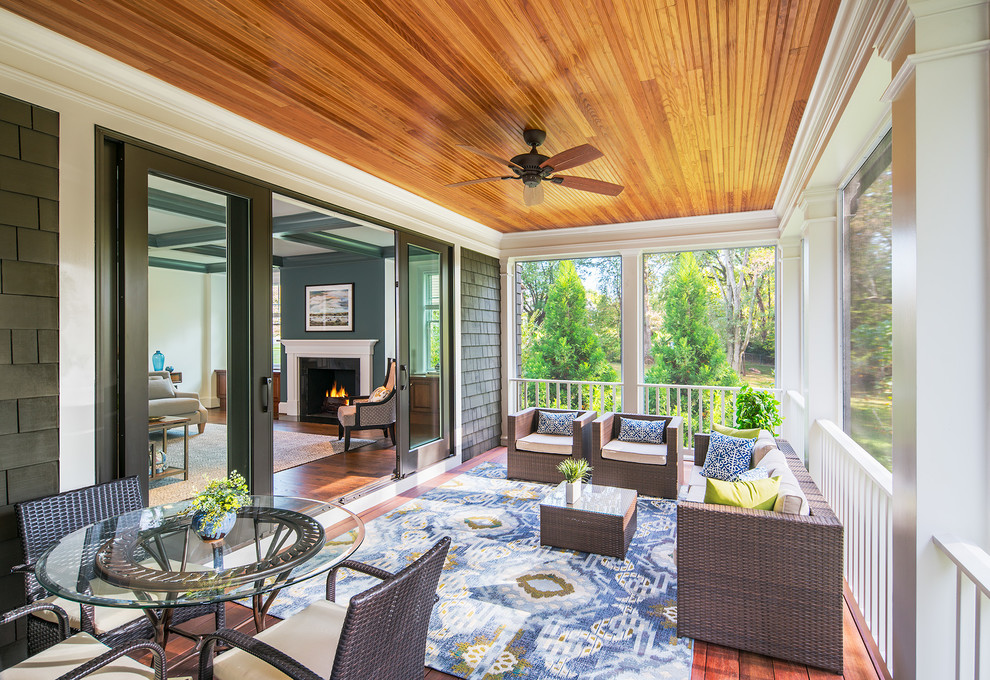 This is an example of a medium sized traditional back screened veranda in DC Metro with a roof extension and decking.