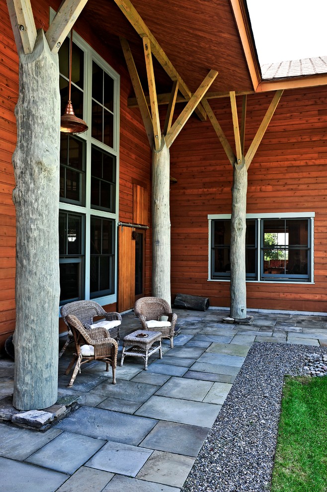Exemple d'un porche d'entrée de maison montagne avec des pavés en béton et une extension de toiture.