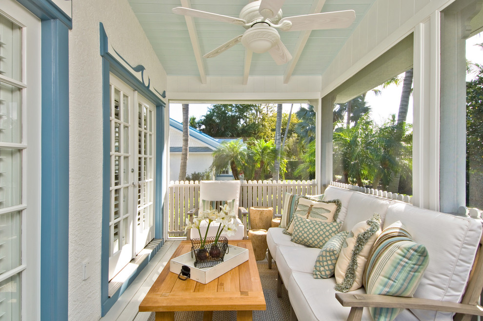 Diseño de terraza tropical en anexo de casas con entablado y todos los revestimientos