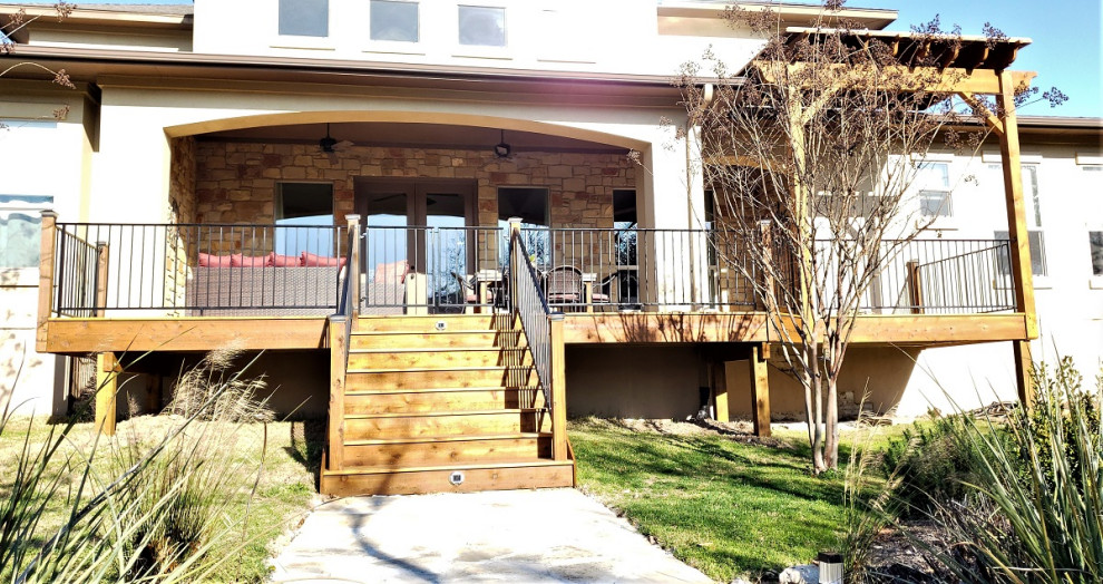 Große Urige Veranda hinter dem Haus mit Pergola und Stahlgeländer in Austin