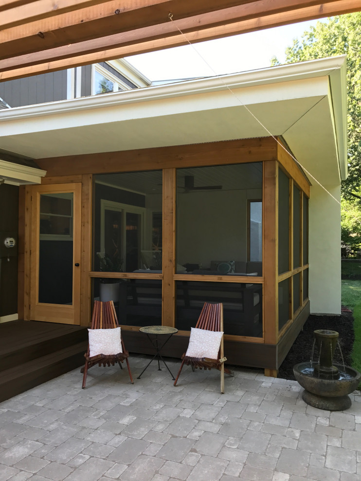 Cette photo montre un porche d'entrée de maison arrière tendance de taille moyenne avec une moustiquaire, des pavés en béton et une extension de toiture.