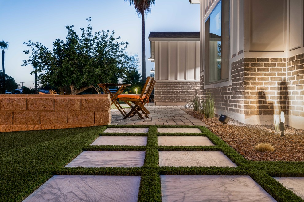 Modelo de terraza moderna de tamaño medio en patio delantero con adoquines de hormigón