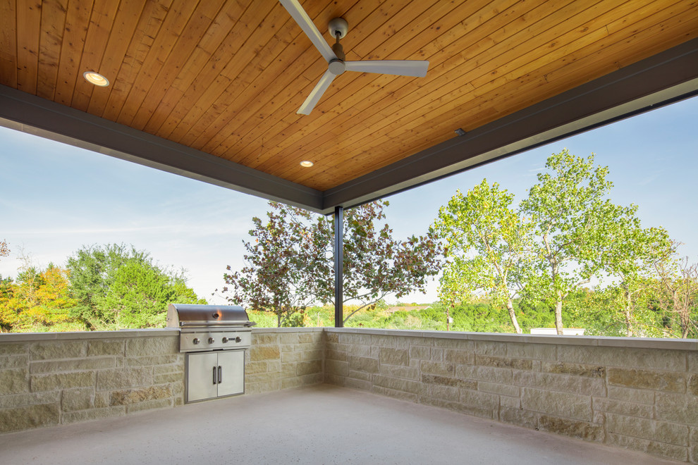 На фото: веранда среднего размера в современном стиле с летней кухней, покрытием из бетонных плит и навесом