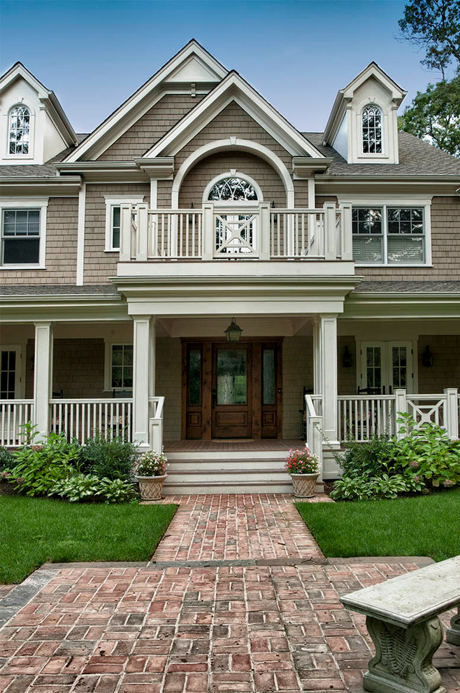 Imagen de terraza clásica grande en patio delantero y anexo de casas con adoquines de ladrillo