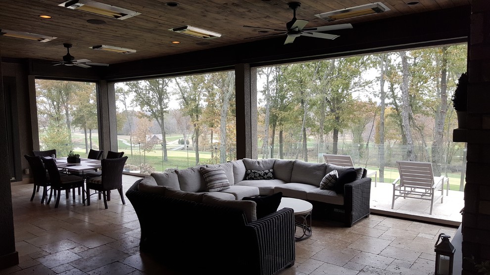 This is an example of a medium sized modern back screened veranda in Kansas City with natural stone paving and a roof extension.