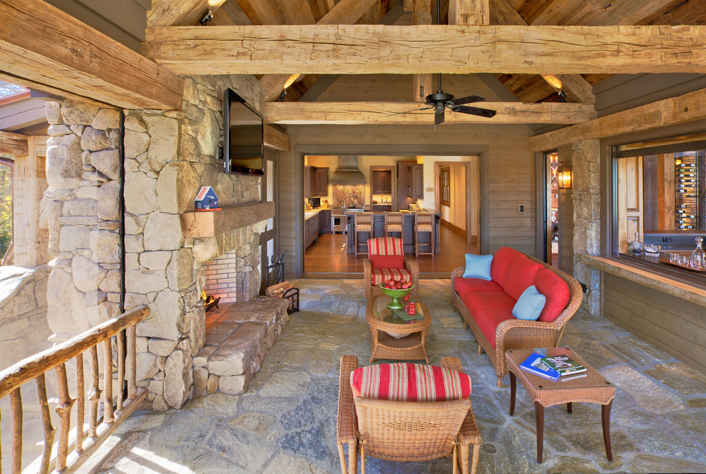Design ideas for a rustic veranda in Other with a fire feature, natural stone paving and a roof extension.