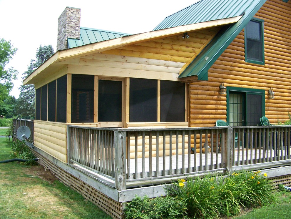 Rustik inredning av en mellanstor innätad veranda på baksidan av huset, med trädäck