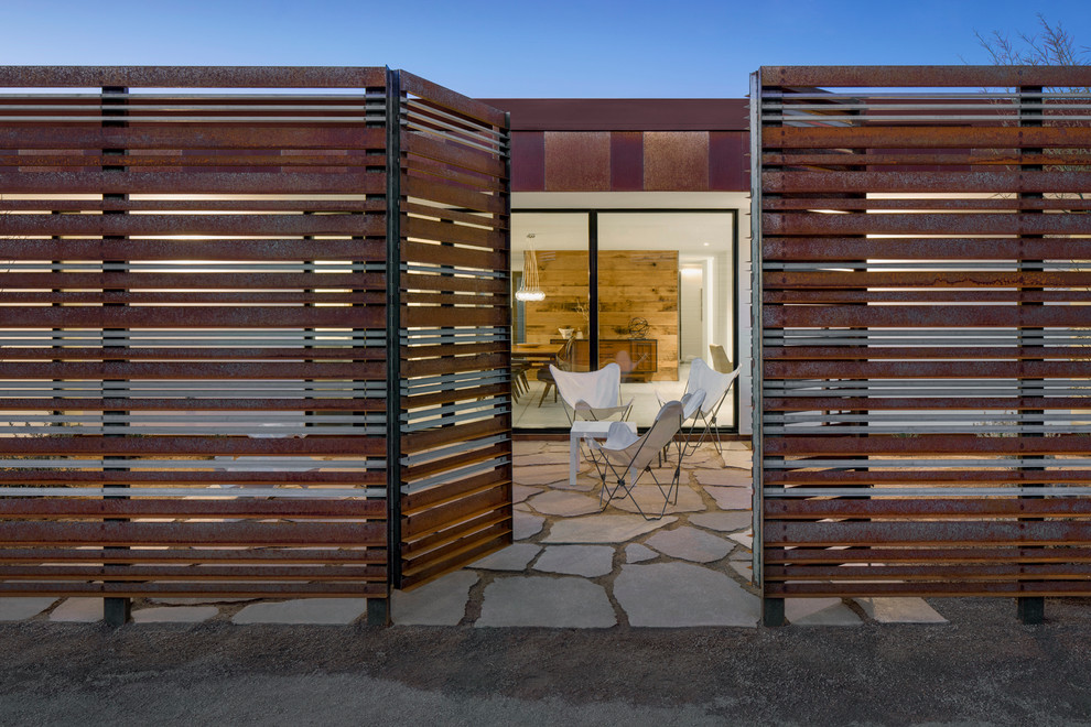Mid-sized minimalist concrete paver front porch idea in Phoenix with a roof extension
