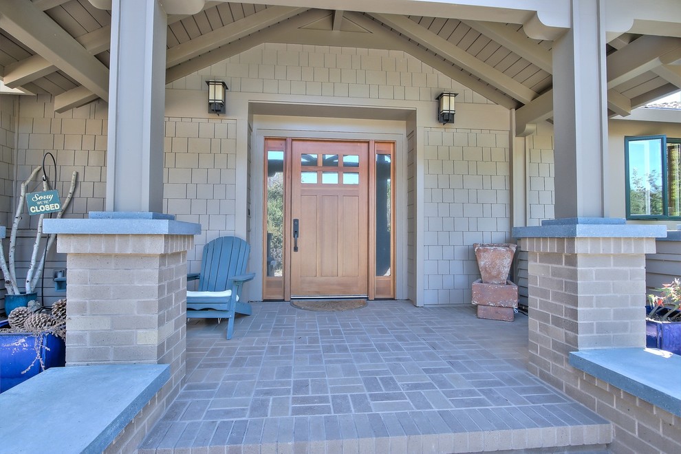 Cette image montre un porche d'entrée de maison avant design avec des pavés en brique et une extension de toiture.