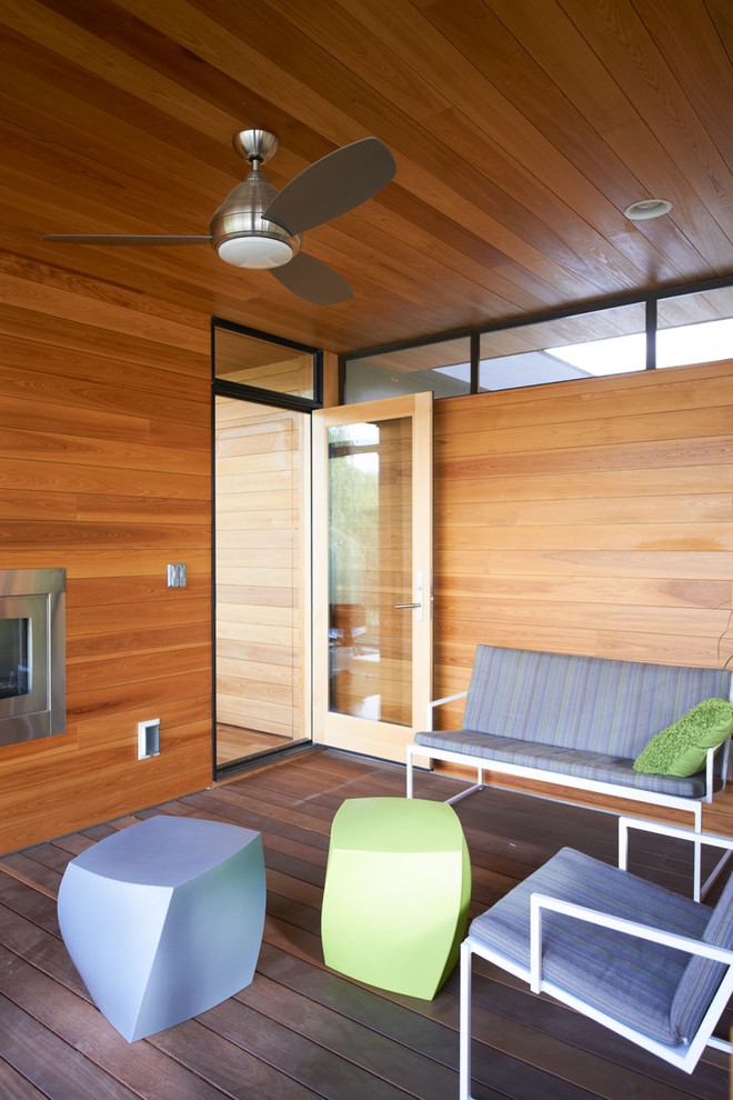 Inspiration pour un porche d'entrée de maison minimaliste avec une terrasse en bois et une extension de toiture.