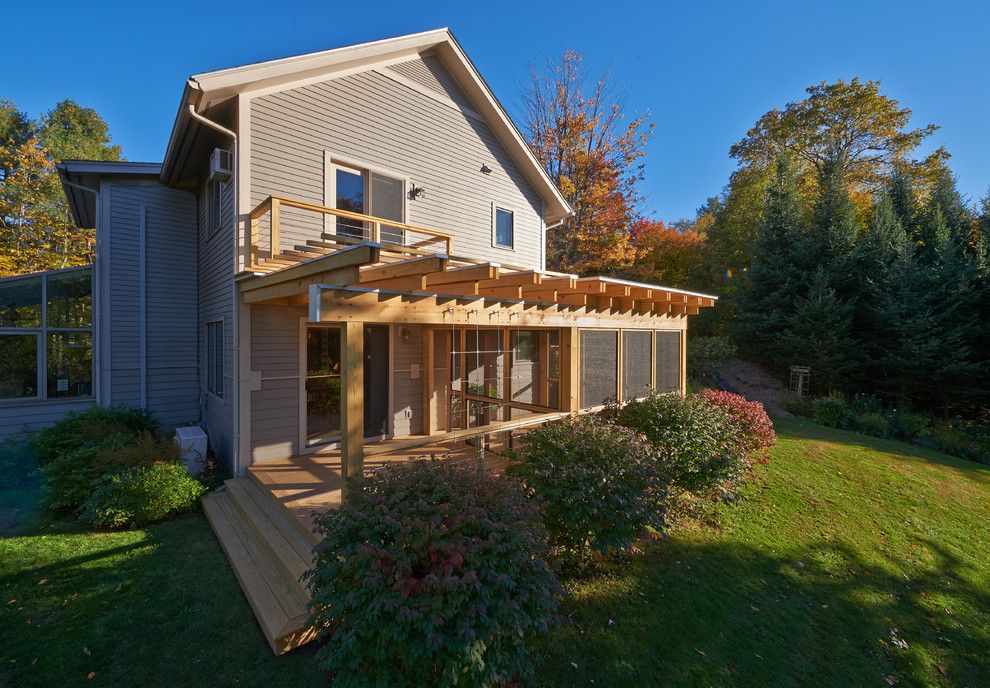 This is an example of a mid-sized modern screened-in side porch design in Burlington with a pergola.