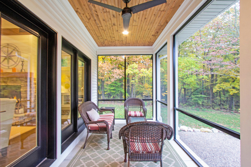 Cette photo montre un porche d'entrée de maison arrière de taille moyenne avec une moustiquaire, une dalle de béton et une extension de toiture.