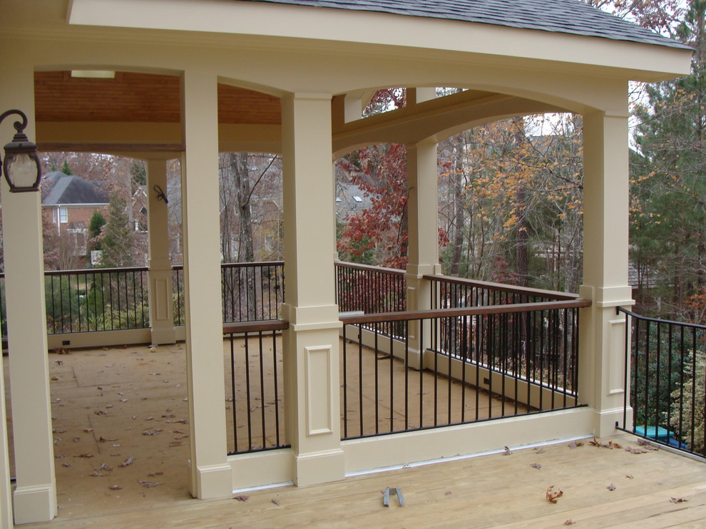 Inspiration pour un grand porche d'entrée de maison arrière traditionnel avec une moustiquaire et une extension de toiture.