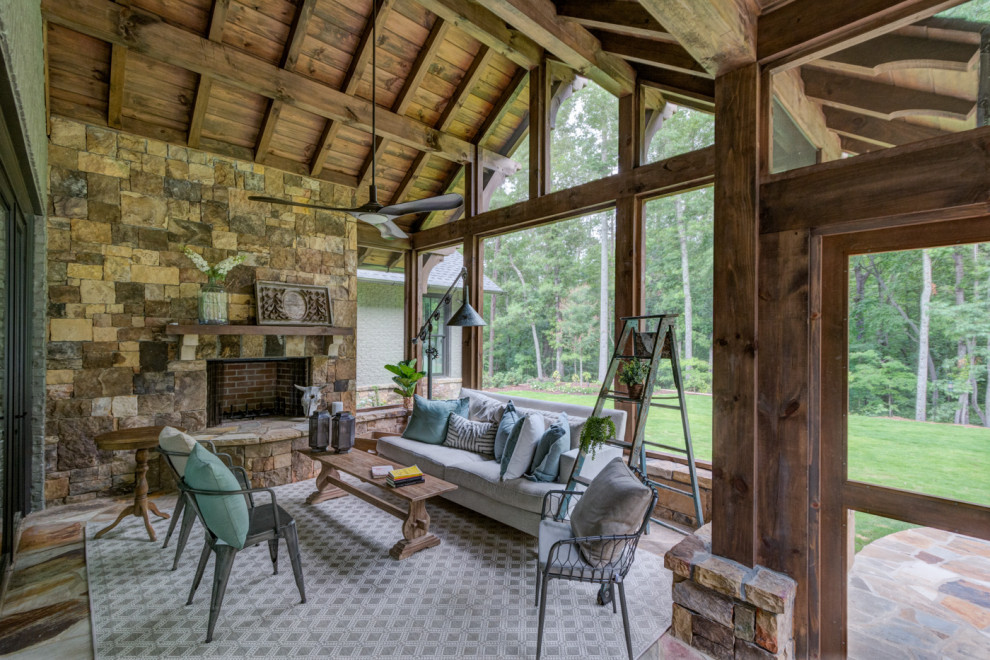 Réalisation d'un grand porche d'entrée de maison arrière chalet avec une moustiquaire, des pavés en pierre naturelle et une extension de toiture.
