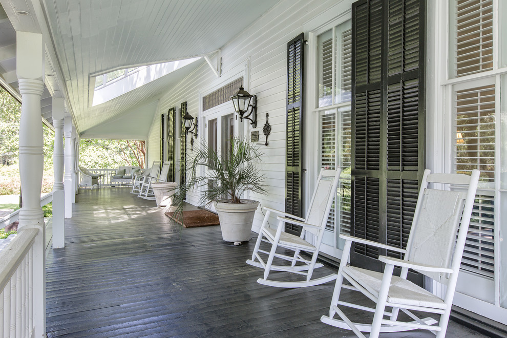 Huge farmhouse porch idea in Miami with decking and a roof extension