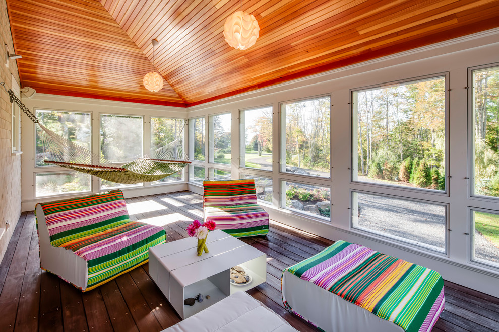 Aménagement d'un porche d'entrée de maison contemporain avec une terrasse en bois, une extension de toiture et tous types de couvertures.