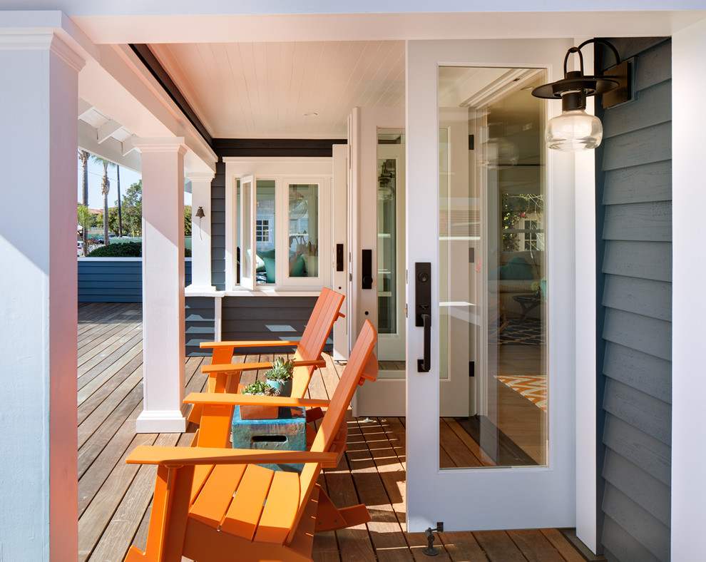 Réalisation d'un porche d'entrée de maison avant marin de taille moyenne avec une terrasse en bois et une extension de toiture.