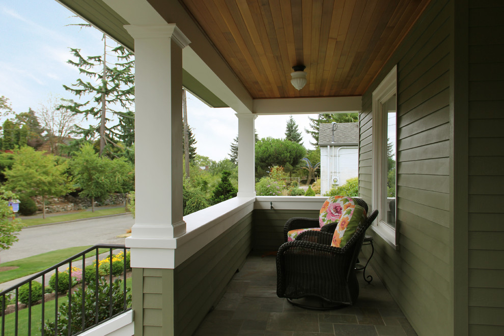 Mid-sized arts and crafts stone front porch idea in Seattle with a roof extension
