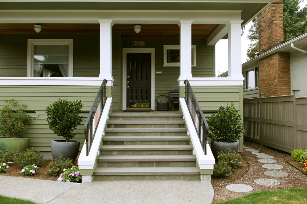 Réalisation d'un porche d'entrée de maison avant craftsman de taille moyenne avec des pavés en pierre naturelle et une extension de toiture.