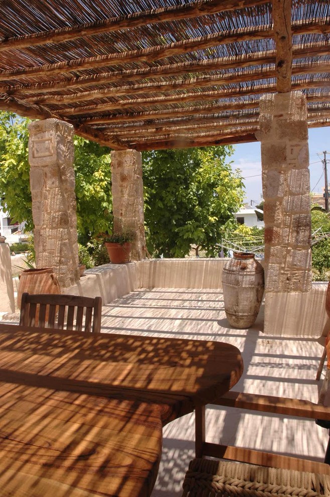 This is an example of a mediterranean veranda in Other with a pergola.