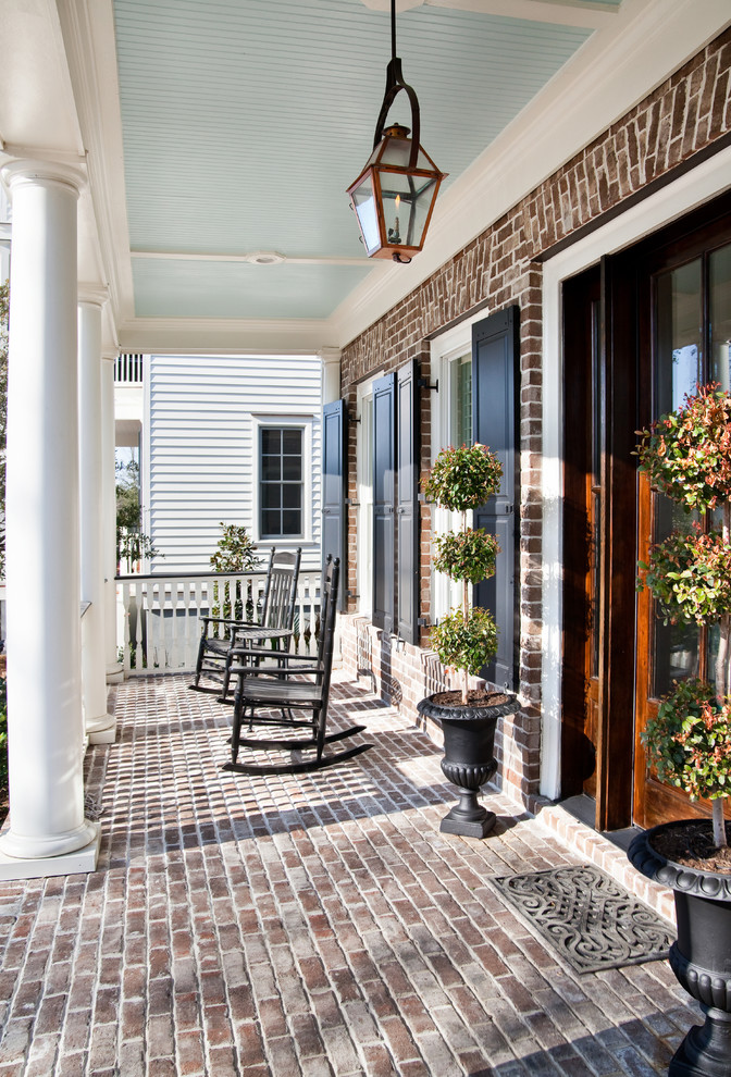 Classic brick porch idea in Charleston with a roof extension