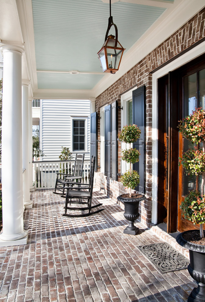 Inspiration for a classic veranda in Charleston with brick paving and a roof extension.