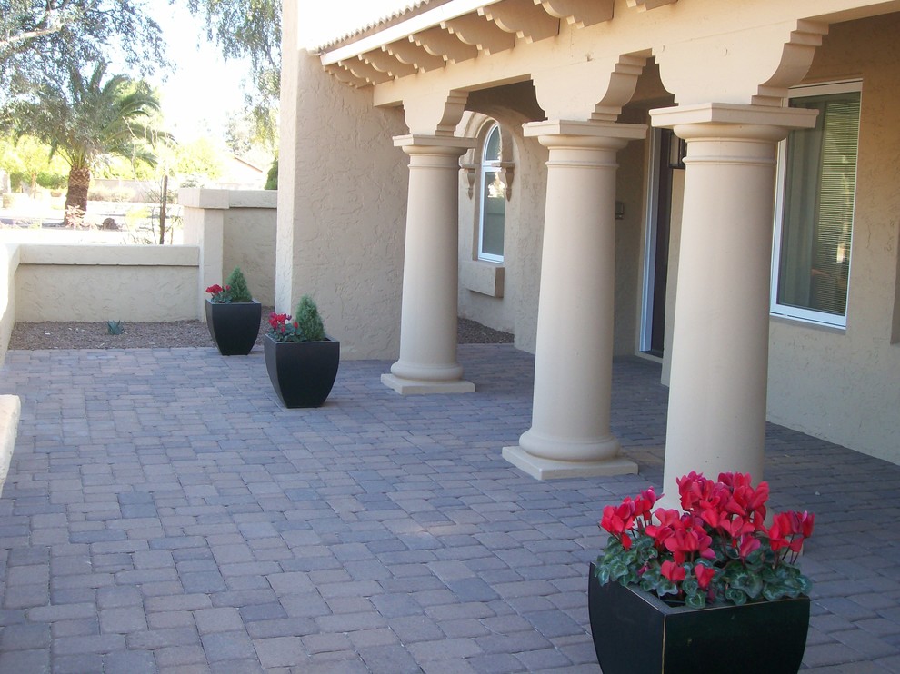 Inspiration for a classic front veranda in Phoenix with brick paving and a roof extension.