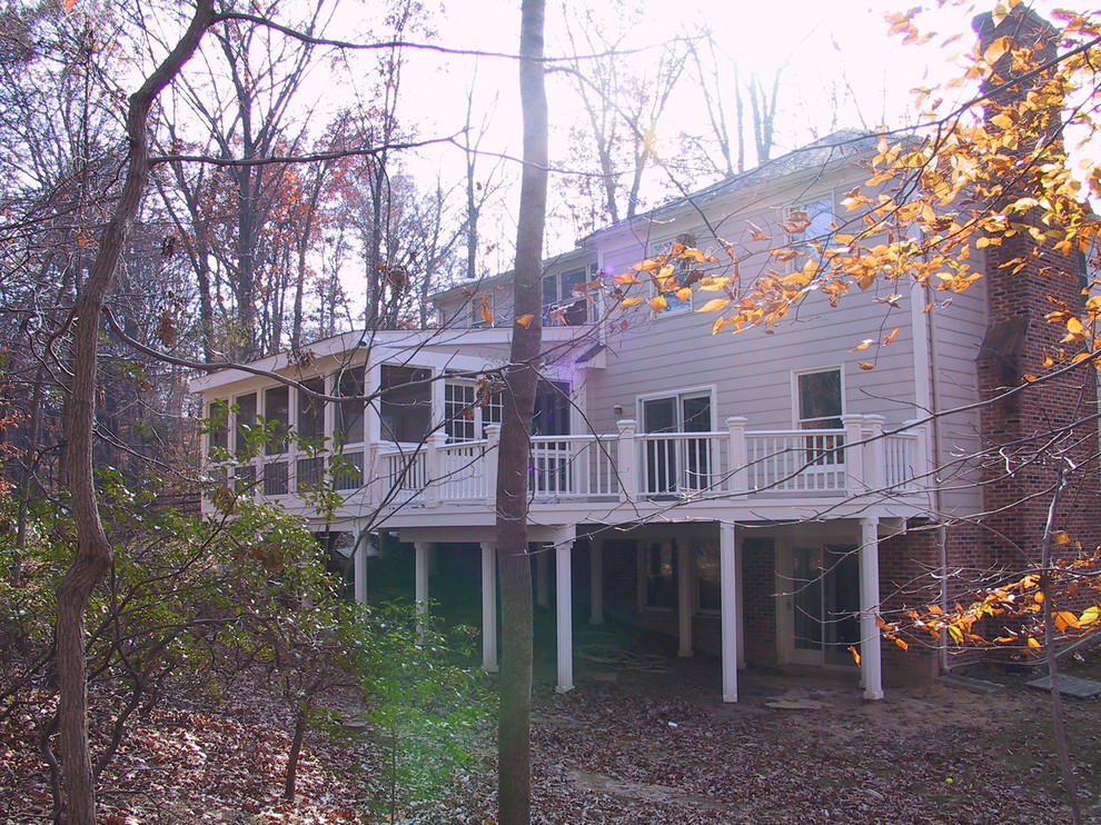 Exemple d'un porche d'entrée de maison arrière chic avec une terrasse en bois et une extension de toiture.