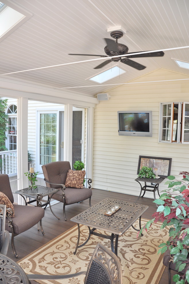 Exemple d'un porche d'entrée de maison arrière avec une moustiquaire et une terrasse en bois.