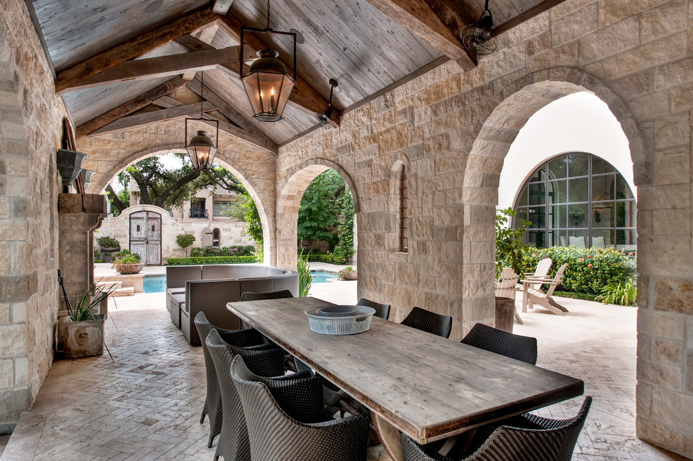 This is an example of a mediterranean veranda in Houston with a fire feature and a roof extension.
