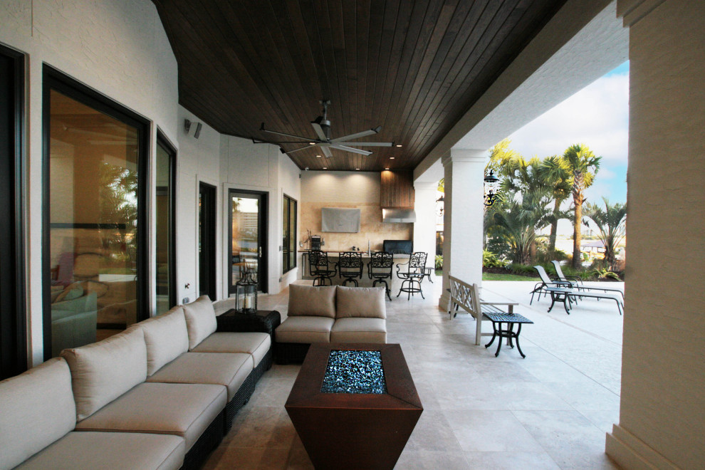 Ejemplo de terraza mediterránea grande en patio trasero y anexo de casas con brasero y suelo de baldosas