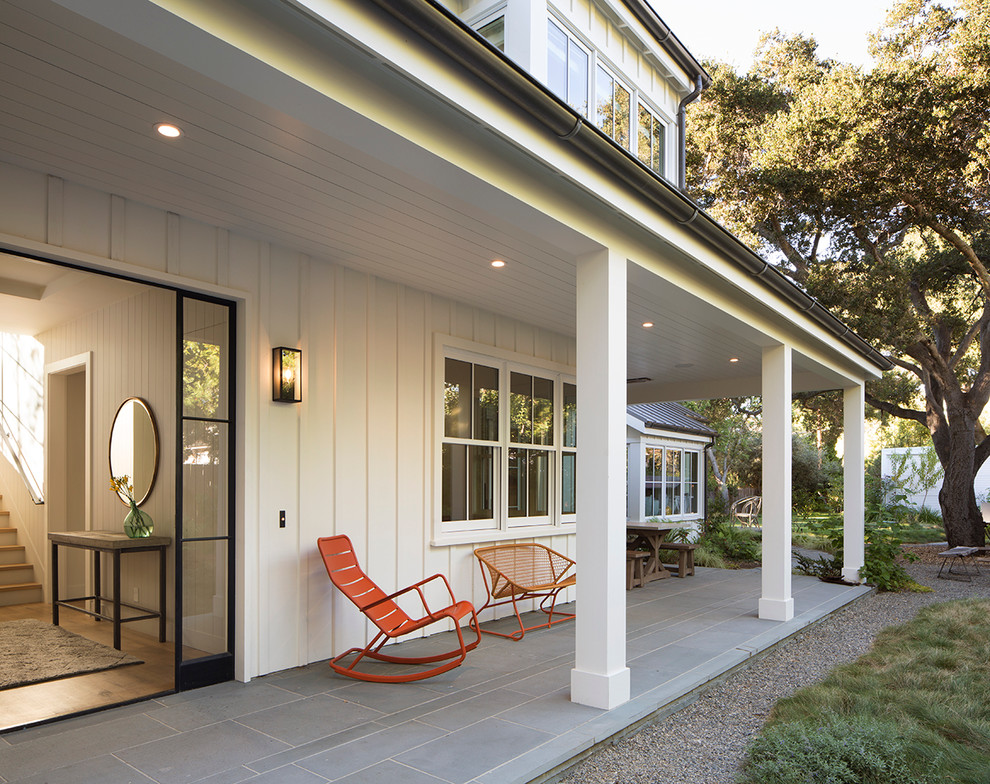 Inspiration för mellanstora lantliga verandor längs med huset, med naturstensplattor och takförlängning