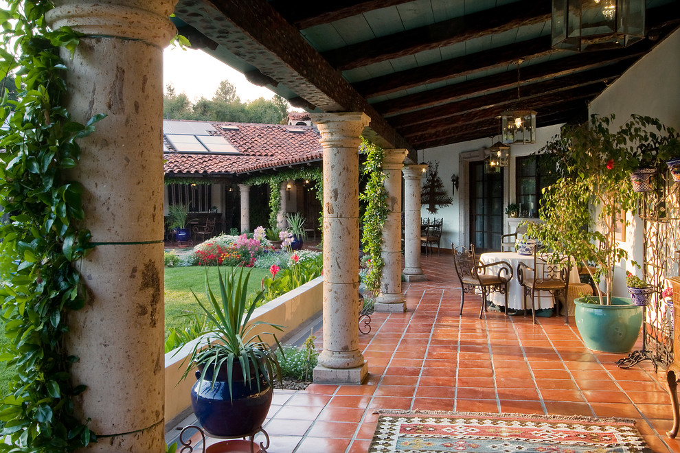 Mediterranean back veranda in San Francisco with tiled flooring and a roof extension.