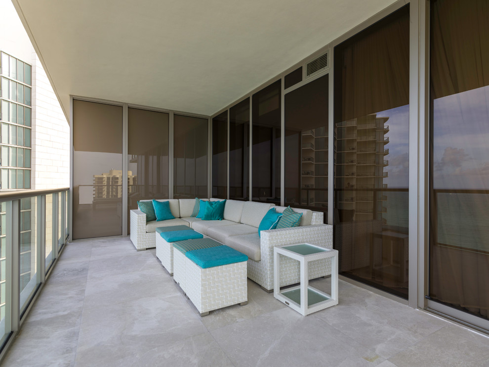 Medium sized beach style veranda in Miami with natural stone paving and a roof extension.