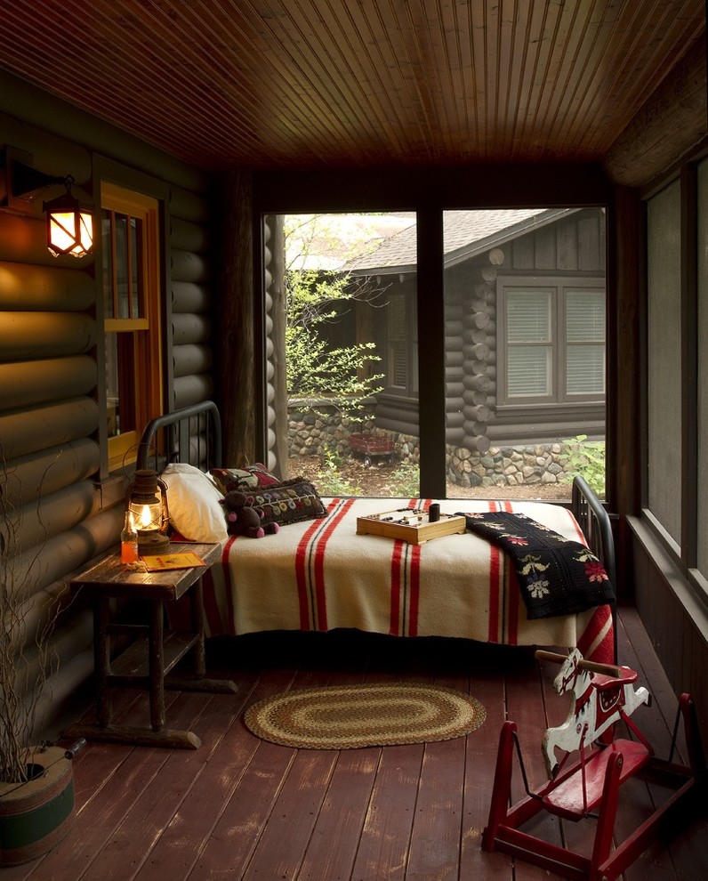 Inspiration for a rustic screened-in porch remodel in Minneapolis with decking and a roof extension