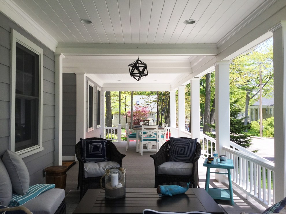 This is an example of a mid-sized coastal front porch design in St Louis with decking and a roof extension.