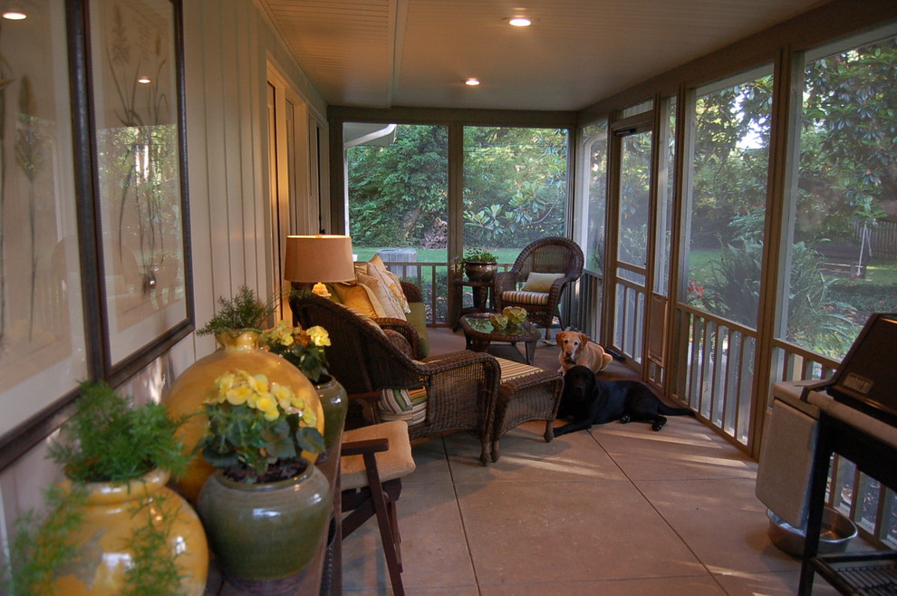Cette image montre un grand porche d'entrée de maison arrière vintage avec une moustiquaire, des pavés en béton et une extension de toiture.