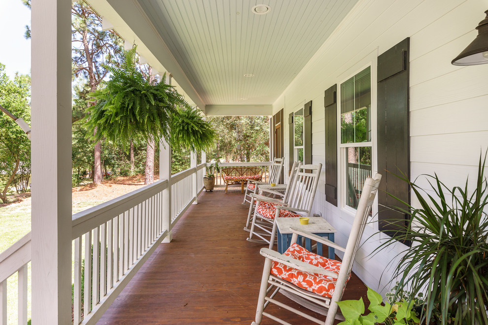 Inspiration för en tropisk veranda på baksidan av huset, med trädäck och takförlängning
