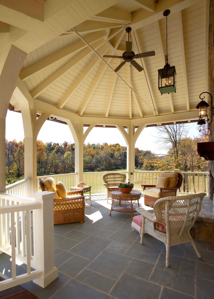 Modelo de terraza rústica de tamaño medio en patio trasero con adoquines de hormigón, pérgola y iluminación