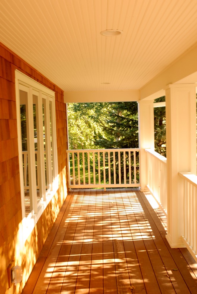 Cette image montre un porche d'entrée de maison avant traditionnel avec une terrasse en bois et une extension de toiture.