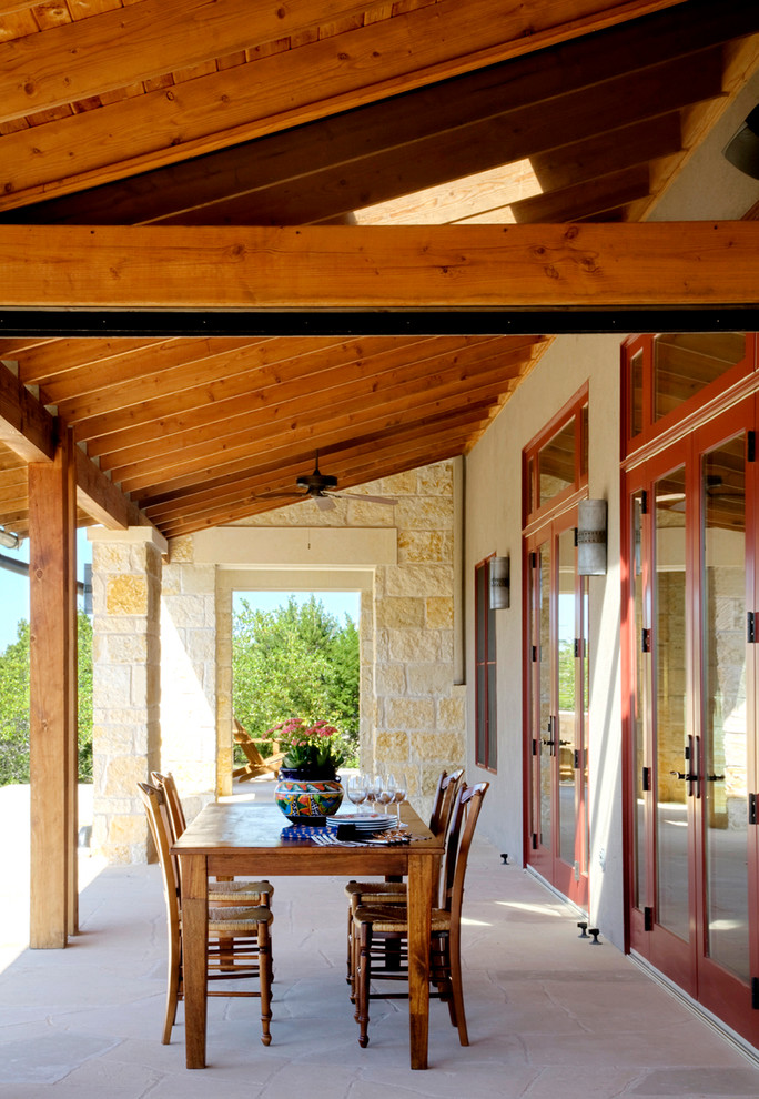 Inredning av en klassisk veranda på baksidan av huset, med naturstensplattor och takförlängning
