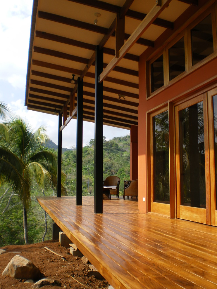 Idéer för mellanstora tropiska verandor på baksidan av huset, med trädäck och takförlängning