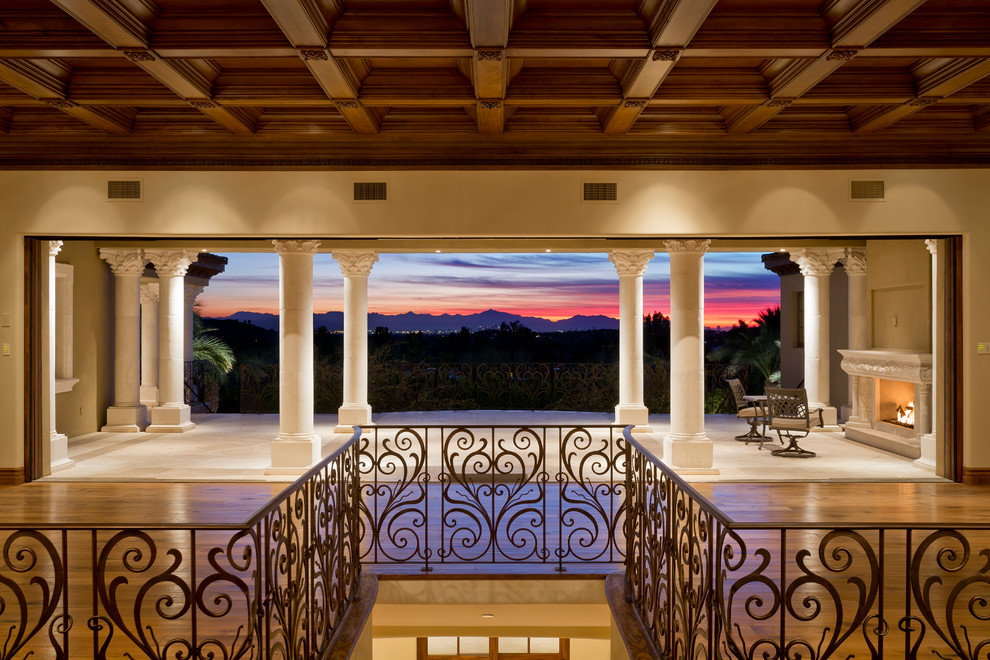 This is an example of a huge mediterranean tile back porch design in Phoenix with a fire pit and a roof extension.