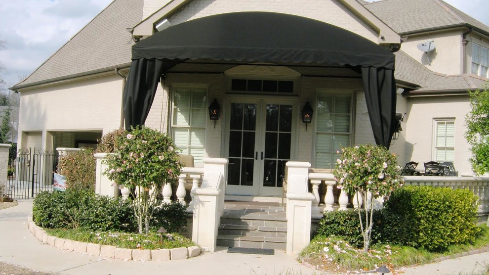 Inspiration för små klassiska verandor längs med huset, med marksten i betong och markiser